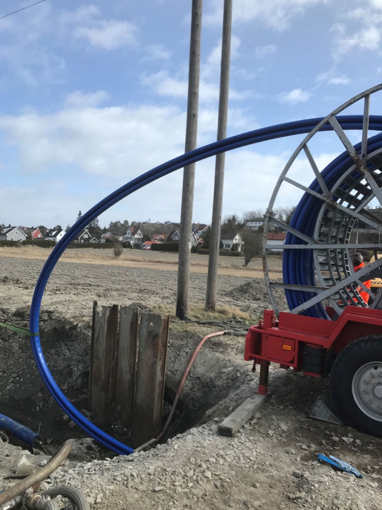 Compact Pipe PE-rør kommer oppkveilet på en stor trommel fra fabrikk. Røret er foldet i en C-form når det blir trukket inn i den gamle vannledningen.